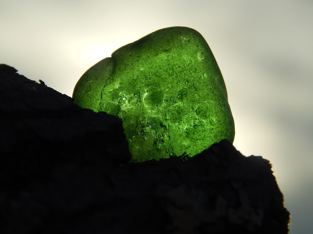 a green rock on a black surface