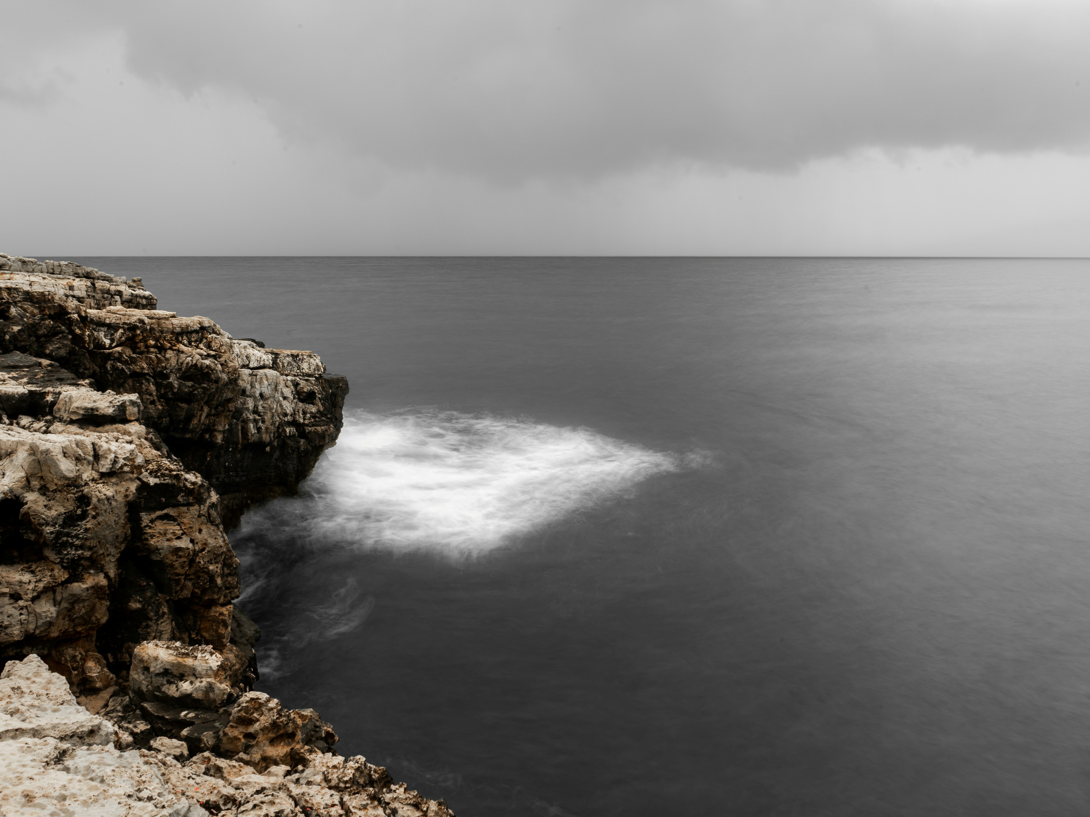 Un acantilado rocoso con vistas a un cuerpo de agua