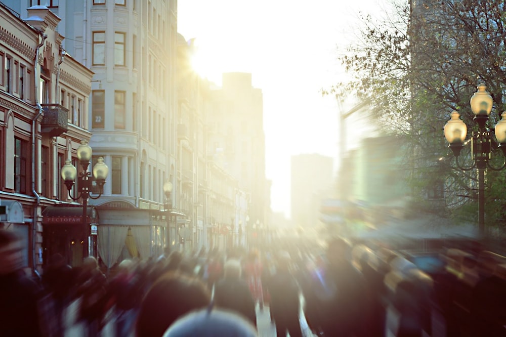 a group of people walking on a street with buildings on either side