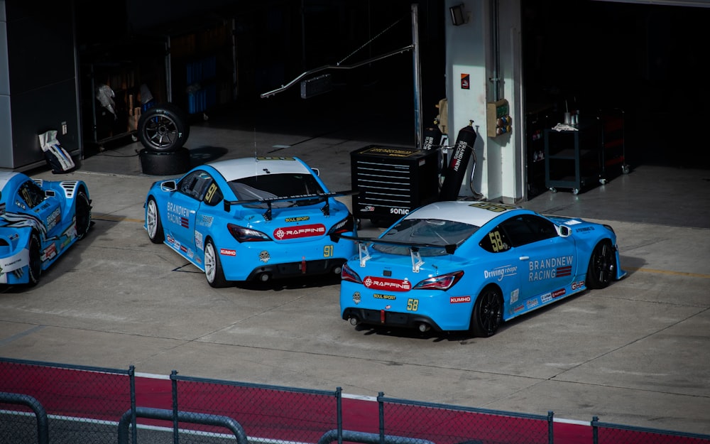 a group of race cars parked in a garage