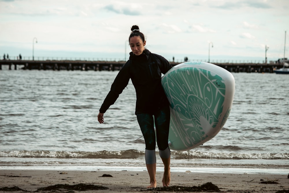 Un uomo che tiene una tavola da surf su una spiaggia