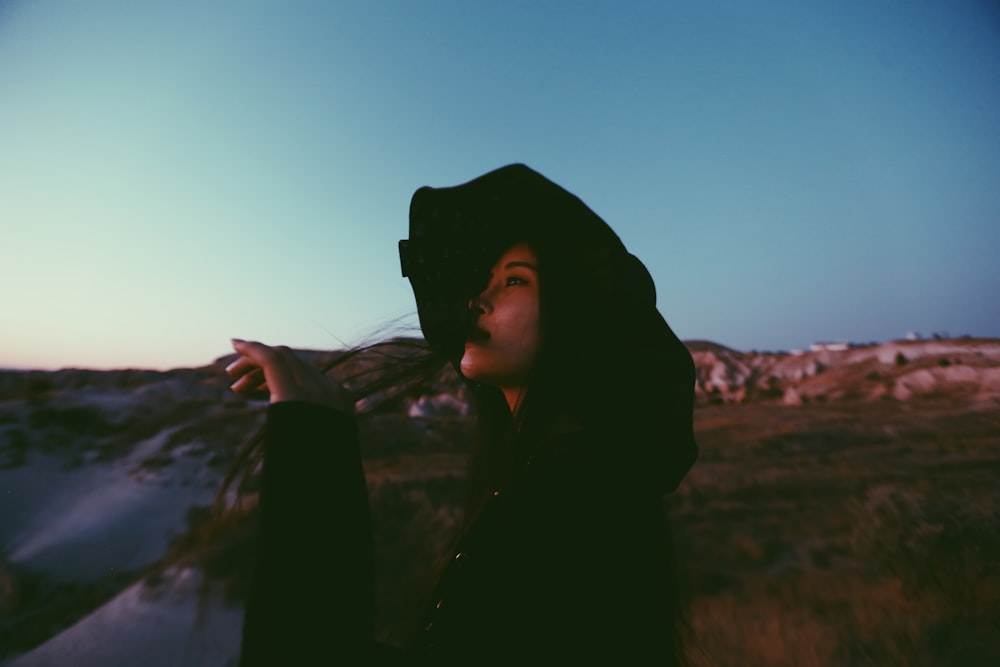 a man wearing a hoodie and standing in a field