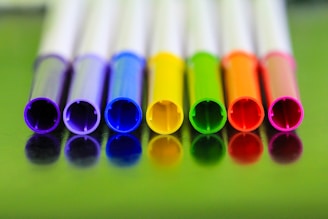A row of colorful padbergpens lined up neatly on a white background.