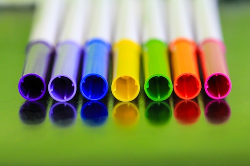 A row of colorful padbergpens lined up neatly on a white background.