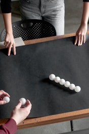 a group of people holding a white board with balls on it