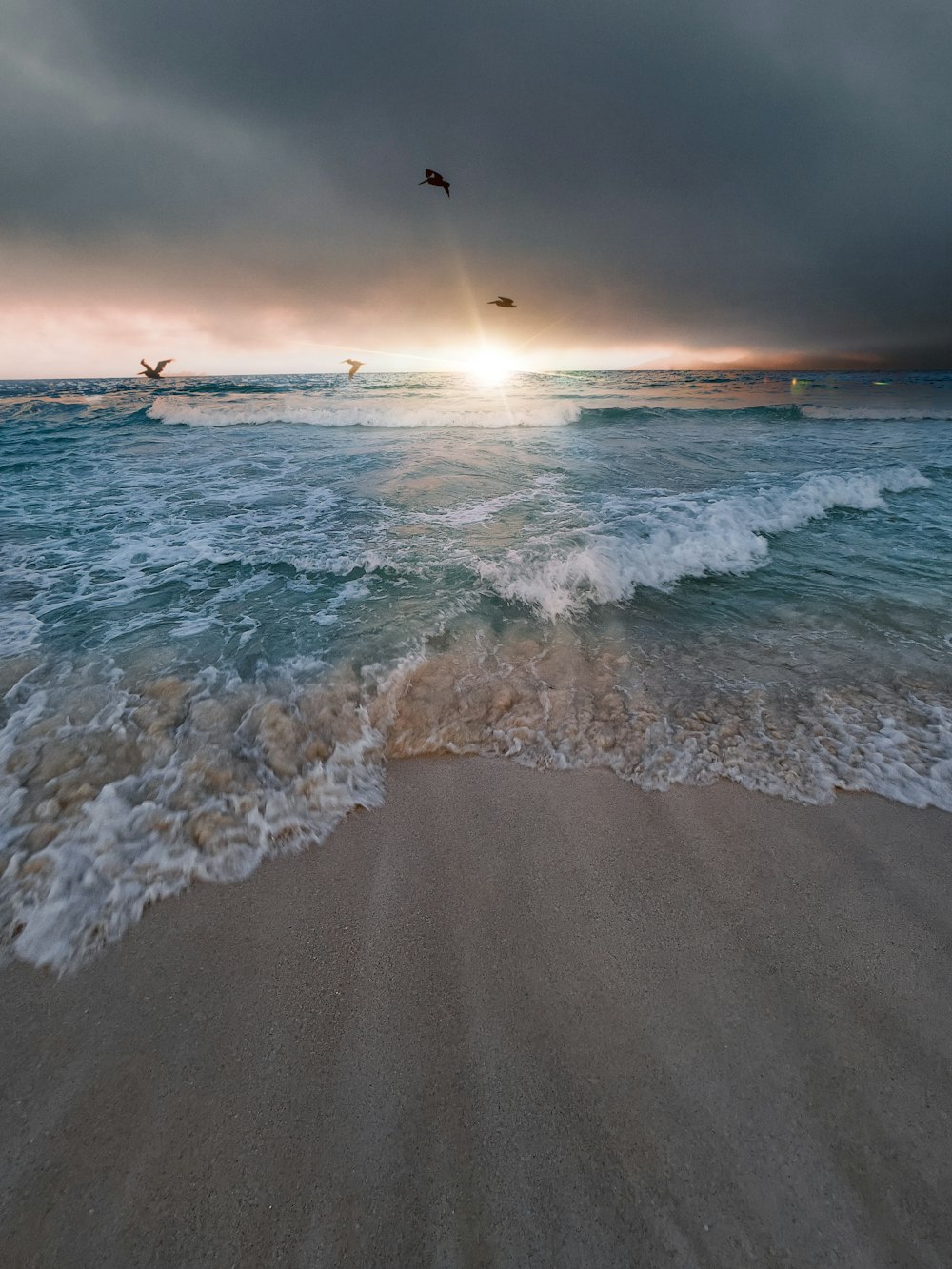 a beach with waves and a sunset