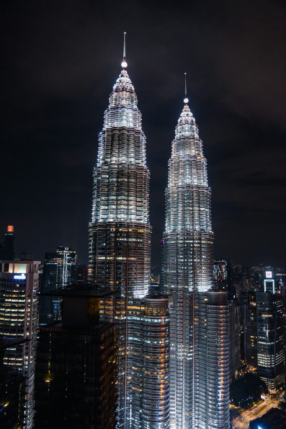 a couple of tall buildings in Petronas Towers at night