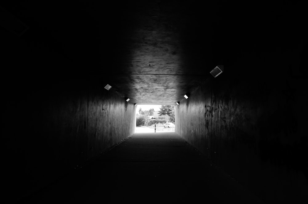 a dark tunnel with a person walking through