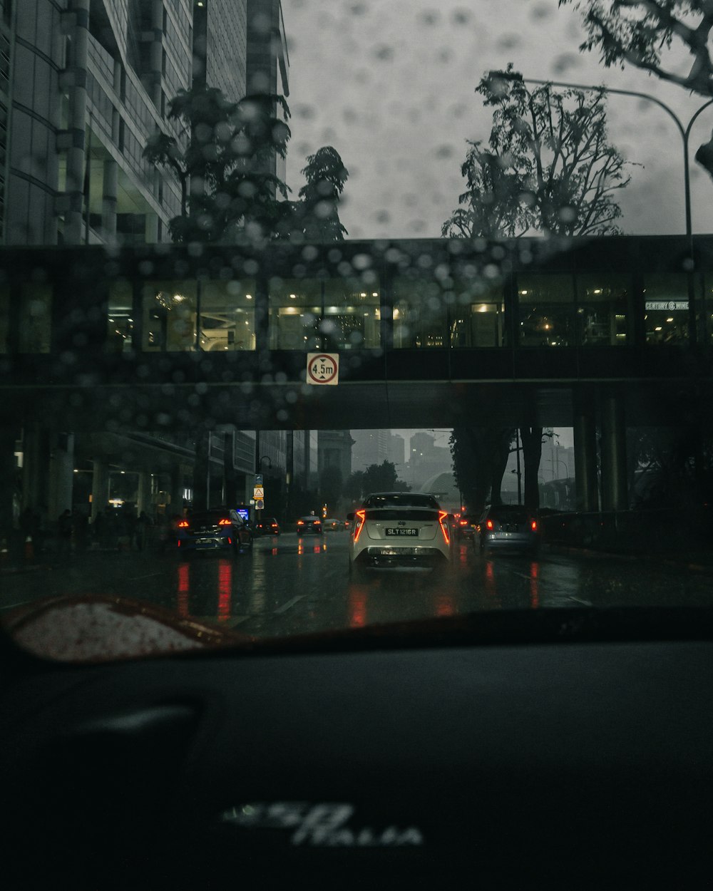 a view of a street through a window of a building with a street and cars on it