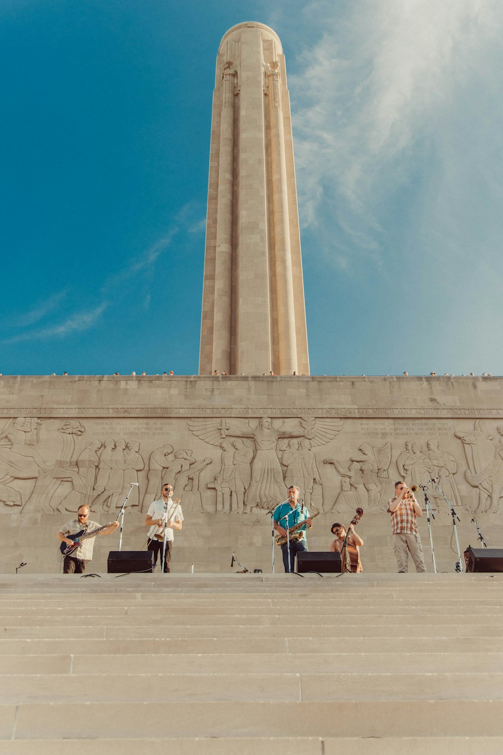 a group of people standing in front of a tall monument