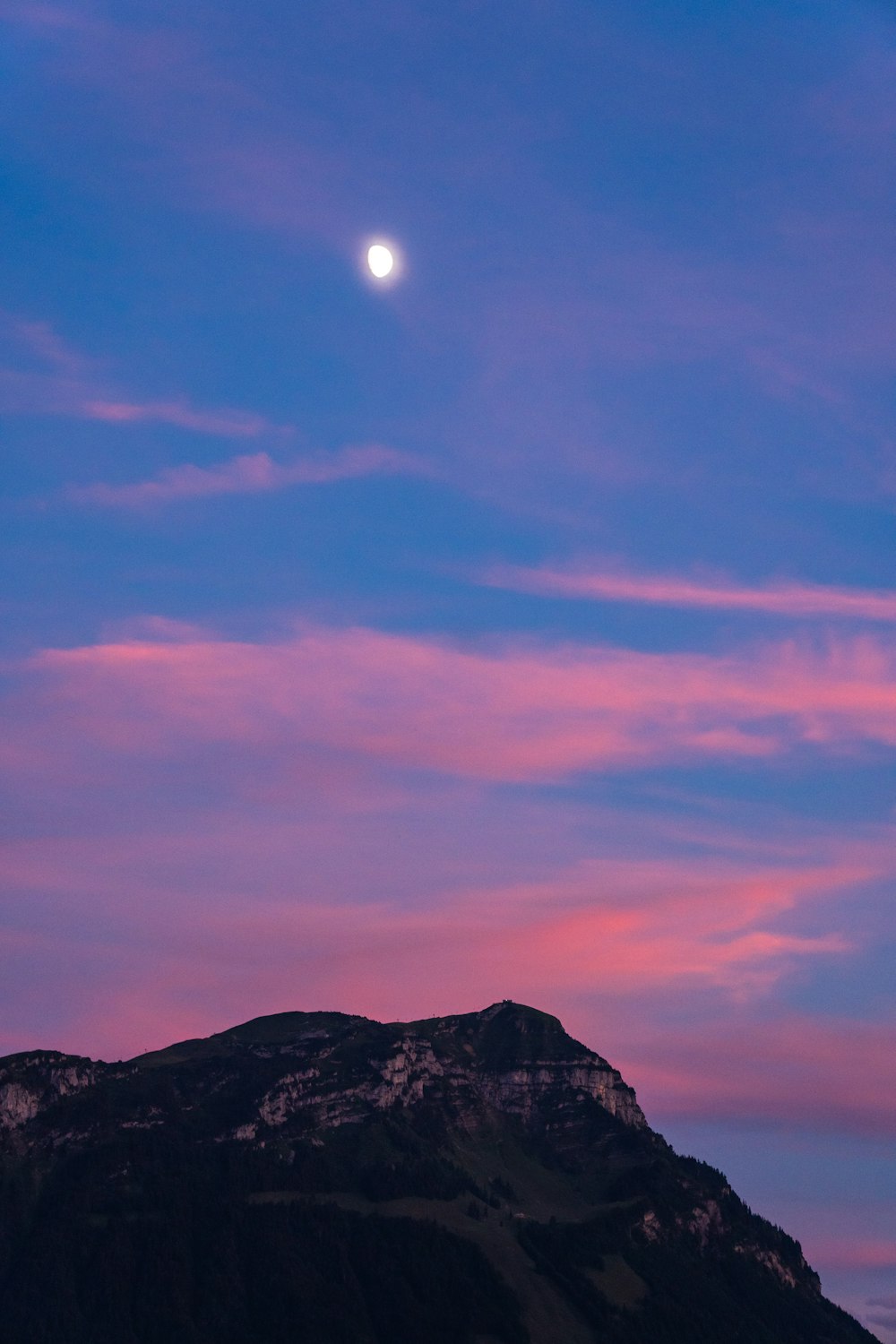 a mountain with a moon in the sky