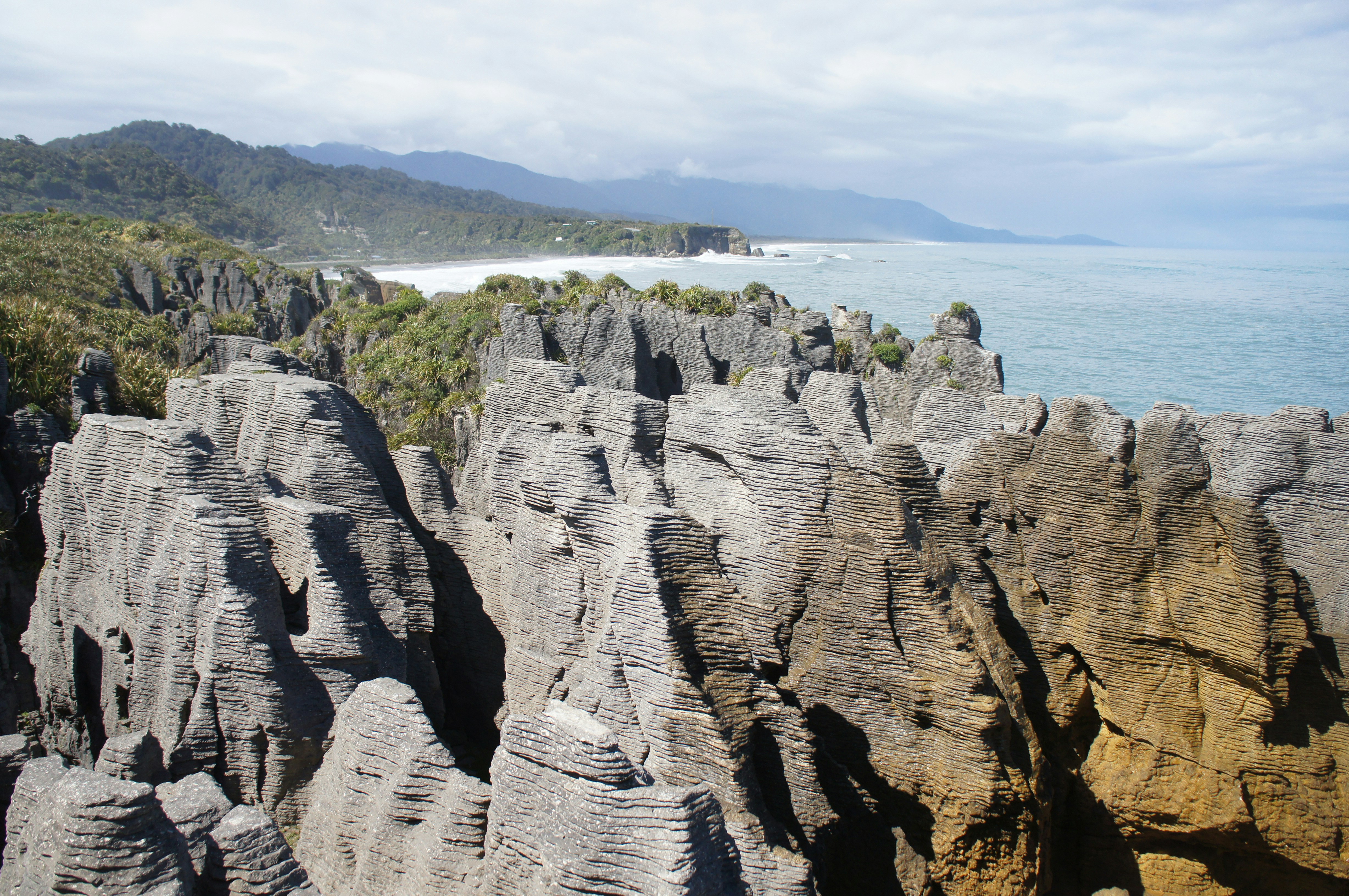 a rocky cliff with a body of water in the background