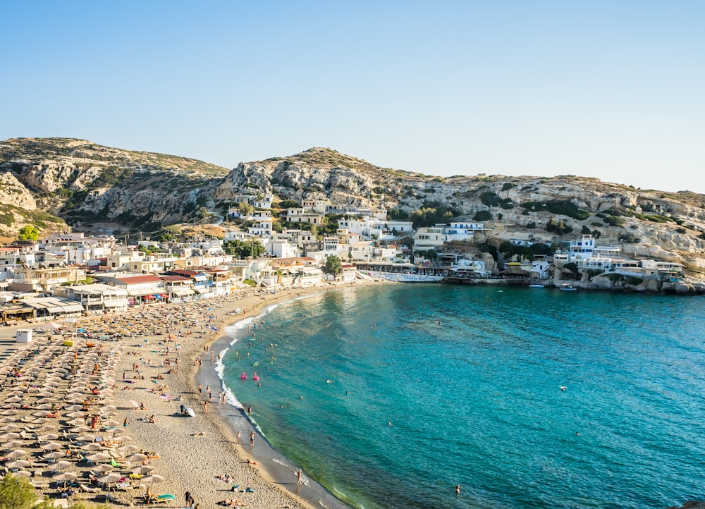 a beach with houses and a hill in the background