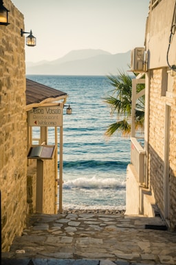 a stone path with a sign on it next to a body of water