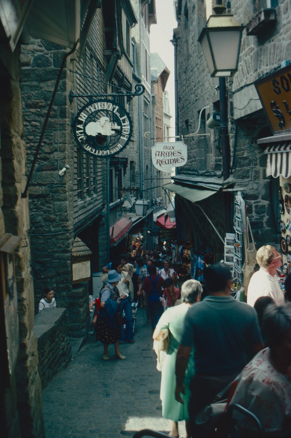 a crowd of people walking down a narrow street