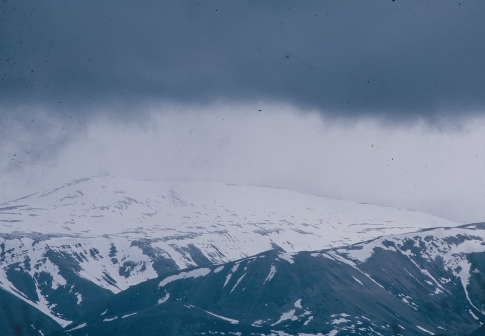 a snowy mountain with clouds