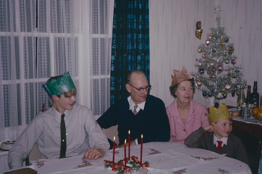 Eine Gruppe von Menschen sitzt um einen Tisch mit einem Weihnachtsbaum