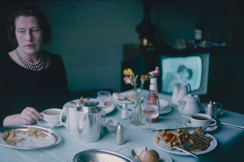 a person sitting at a table with food and drinks