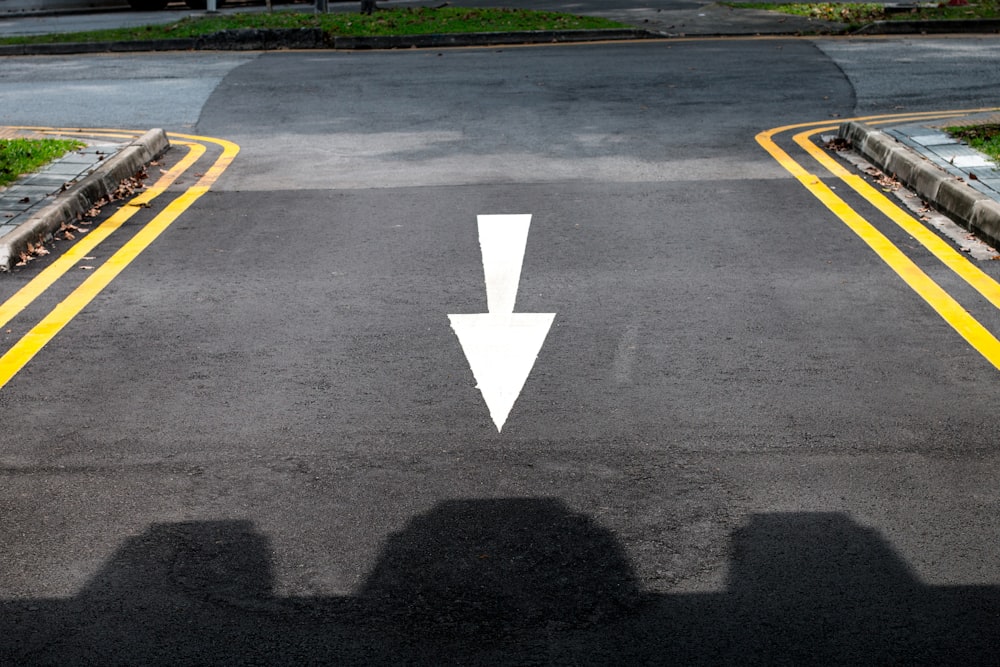 a road with a white arrow