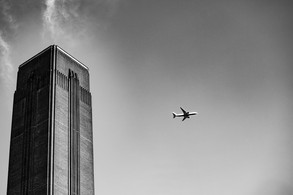 a plane flying over a tall building