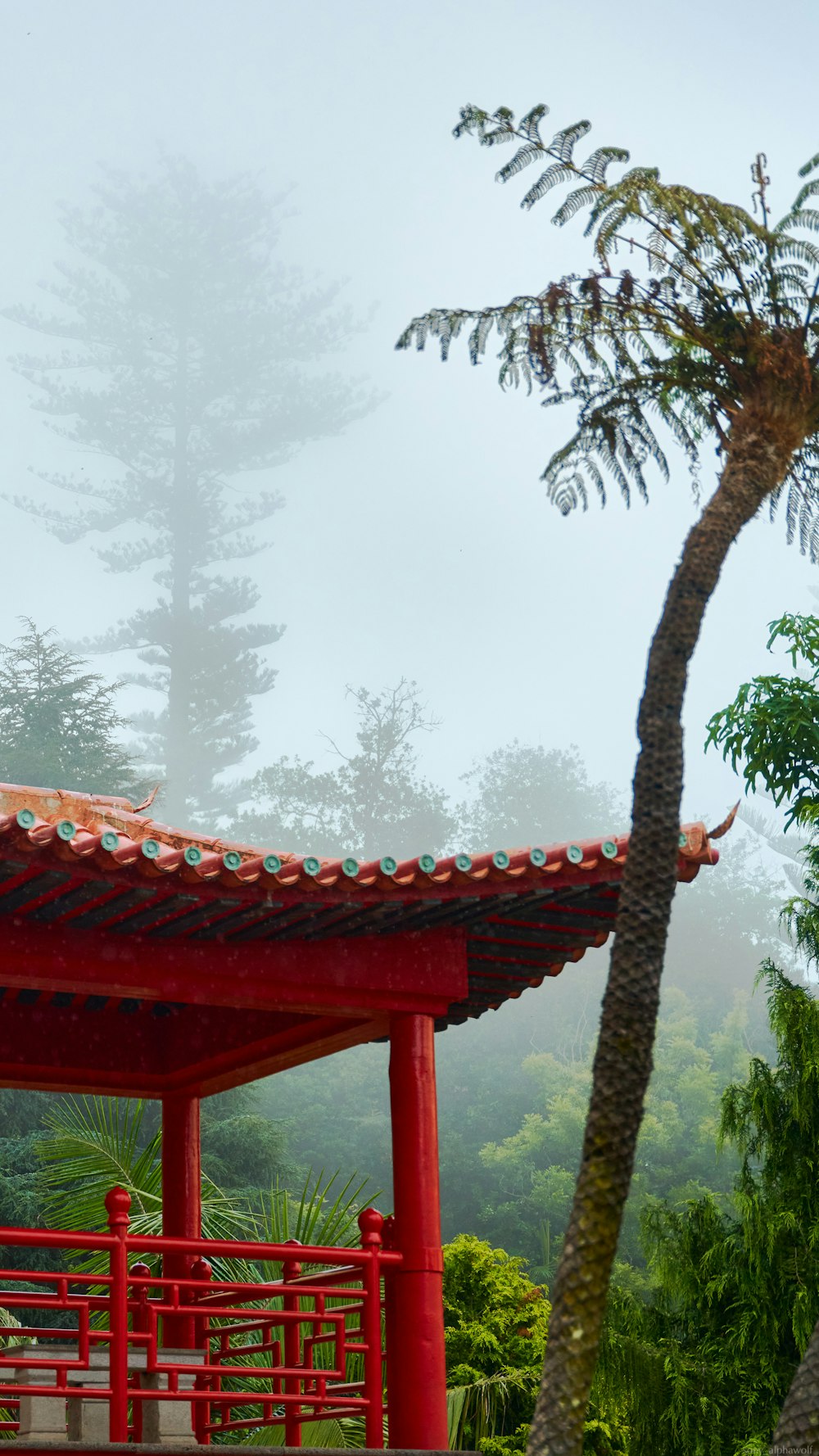 a red pagoda with trees in the background