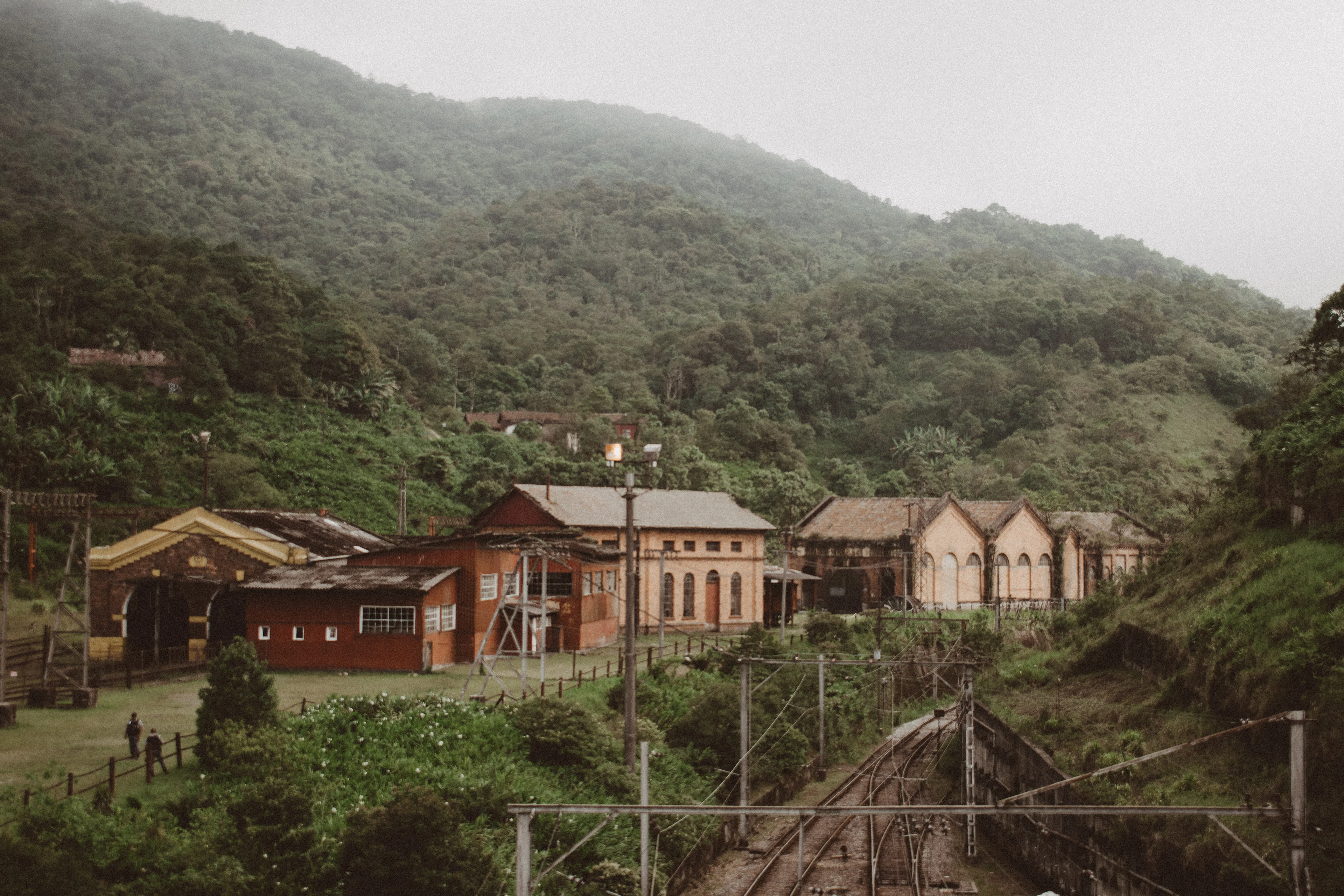 Historic railway-village houses of Paranapiacaba beneath a misty, forested mountain.