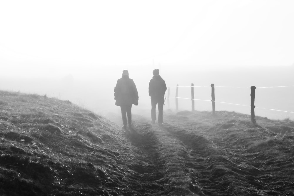 two people walking on a dirt path