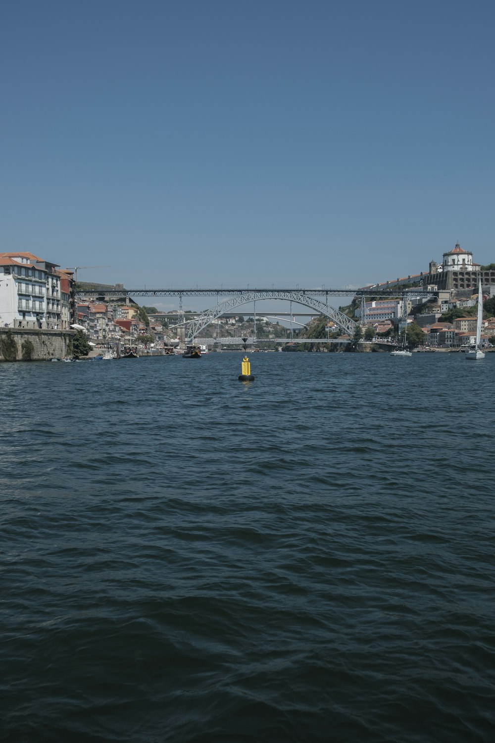 un cuerpo de agua con un puente y edificios al fondo