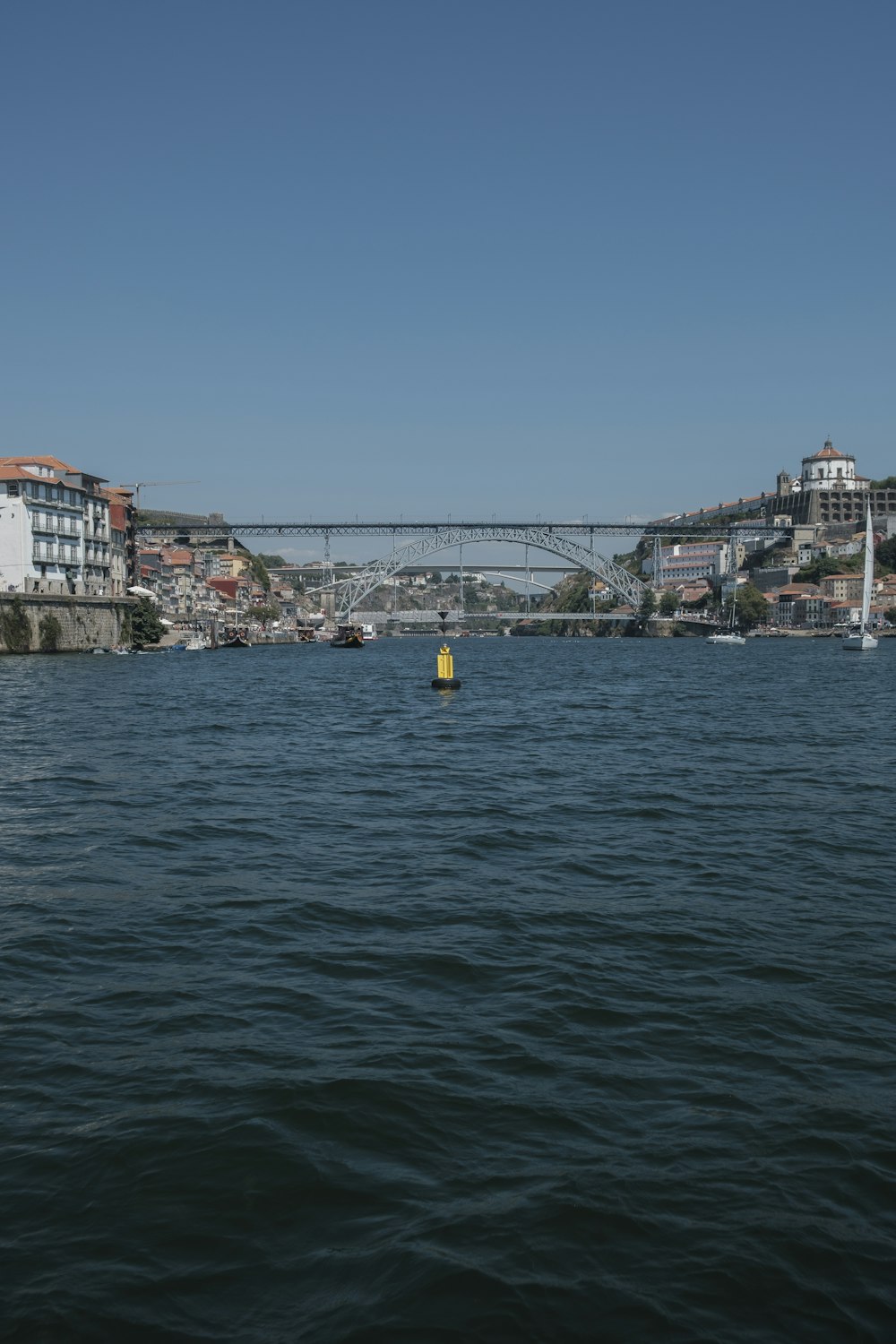 a body of water with a bridge and buildings in the background