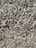 A dense layer of grayish-brown wood chips and bark fragments covers the ground. The texture appears rough and uneven, with various sizes and shapes of wood pieces layered chaotically.