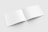 An open, blank booklet with white pages on a light gray background, displayed in a slightly tilted position.