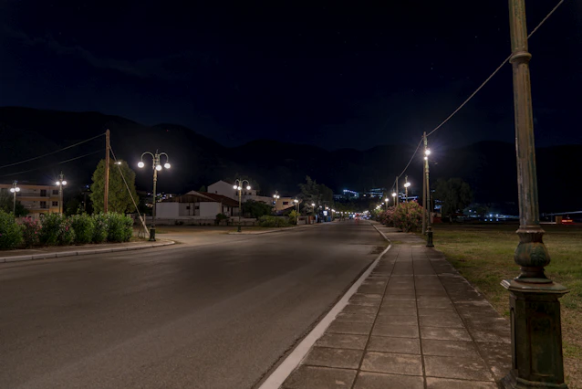 a sidewalk with street lights and buildings