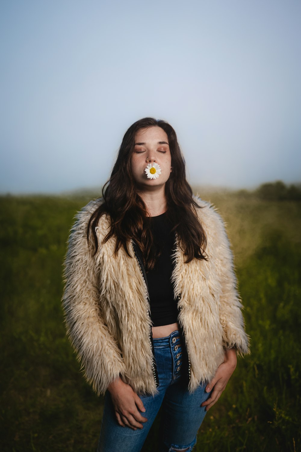 a person with a fur coat and a white flower in the mouth