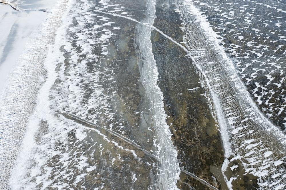 a snowy road with a stream