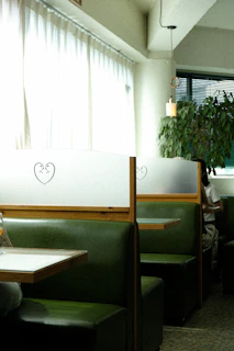 Cozy booth seating with emerald cushions and gold trim, ready for groups and late-night diners.
