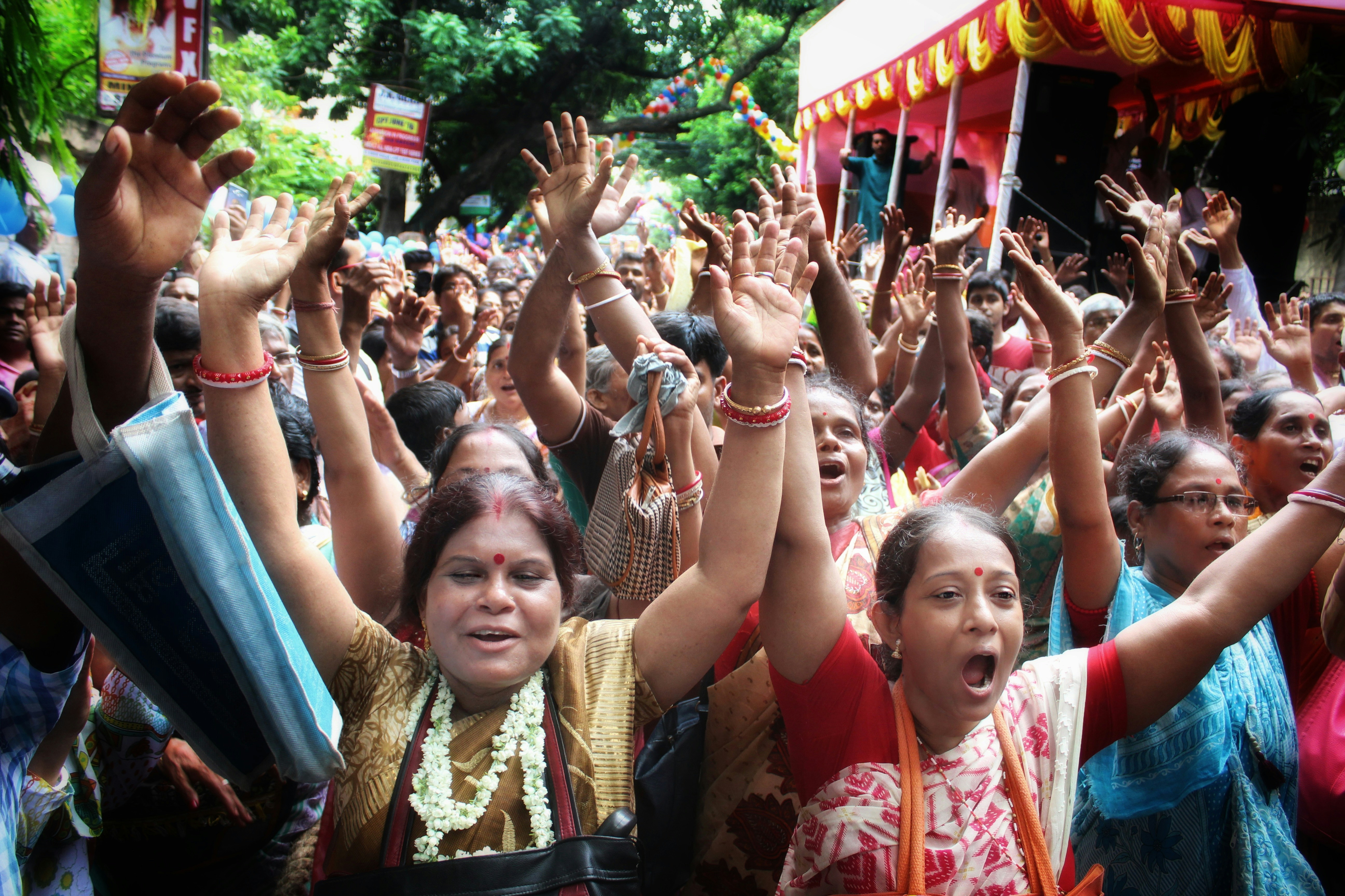 a group of people raising their hands, 