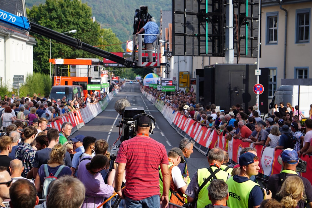 a crowd of people watching a person on a ladder