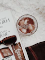 A curated flat lay of vintage sunglasses, a sunhat, and glossy fashion magazines on a wooden table