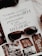 An open magazine displays a page with stylish typography in Portuguese and has a focus on fashion accessories such as sunglasses and jewelry. The sunglasses rest on top of the open page, with additional images showcasing intricate jewelry pieces.