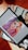 A digital tablet displaying an illustration of a woman with vibrant rainbow-colored hair, featuring shades of purple, green, yellow, and red. The woman's makeup is bold with colorful eyeshadow and red lipstick. The tablet is resting on a stack of magazines, one of which has a black and white cover with a portrait of a person.