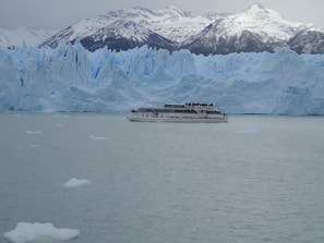 A boat navigating the icy waters of the Beagle Channel with glaciers in the background.