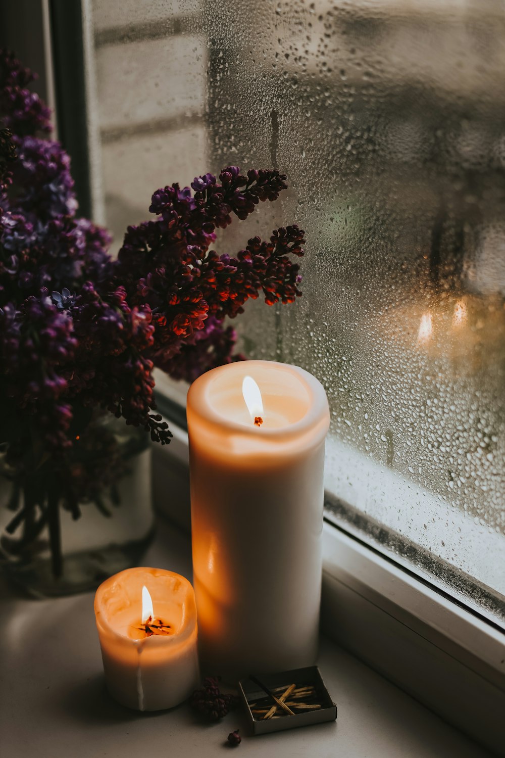 a candle next to a vase of flowers