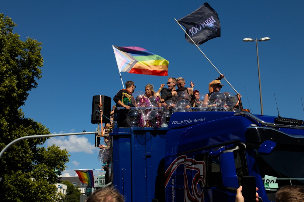 a group of people riding a blue train with flags