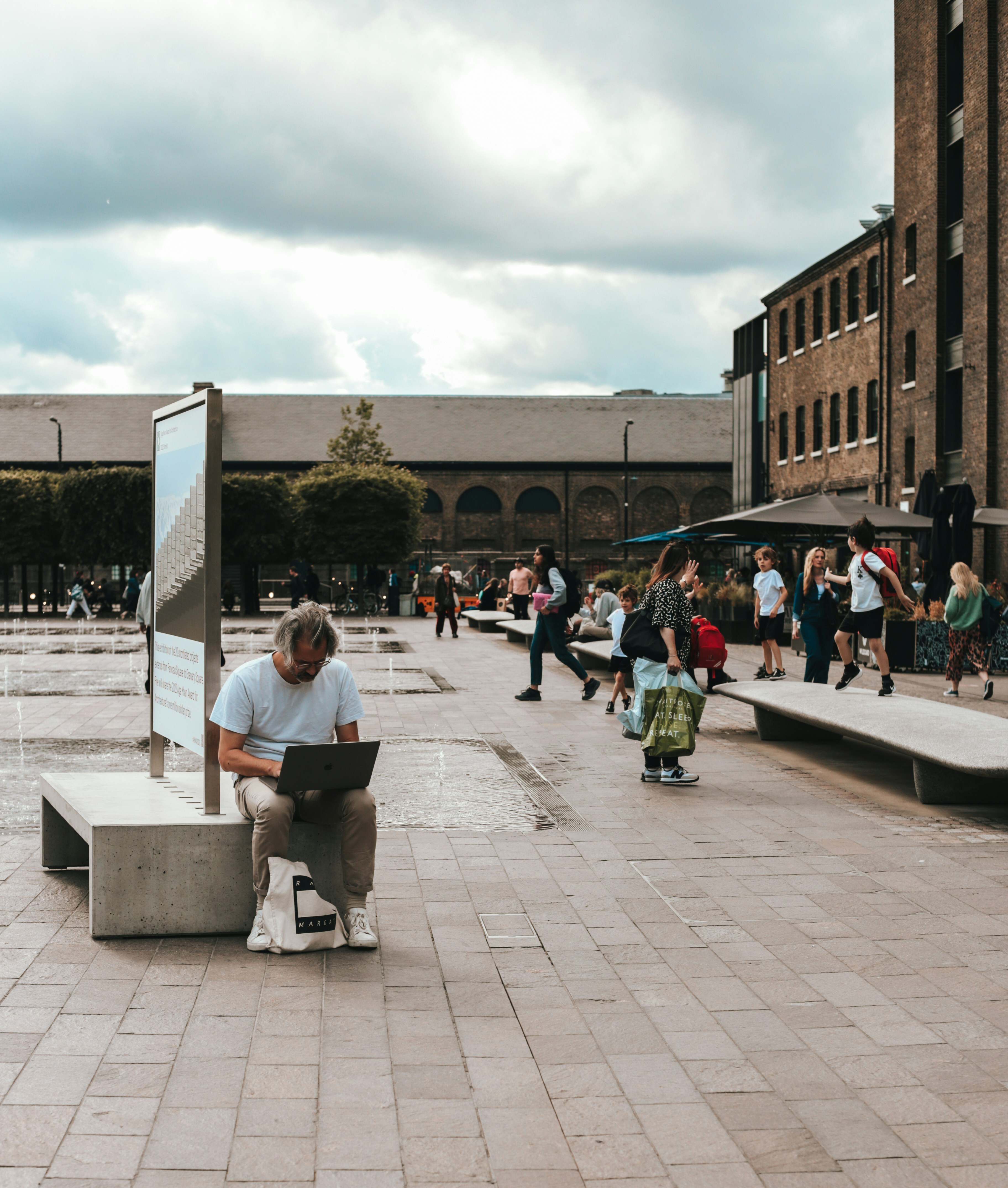 a person sitting on a bench with a laptop