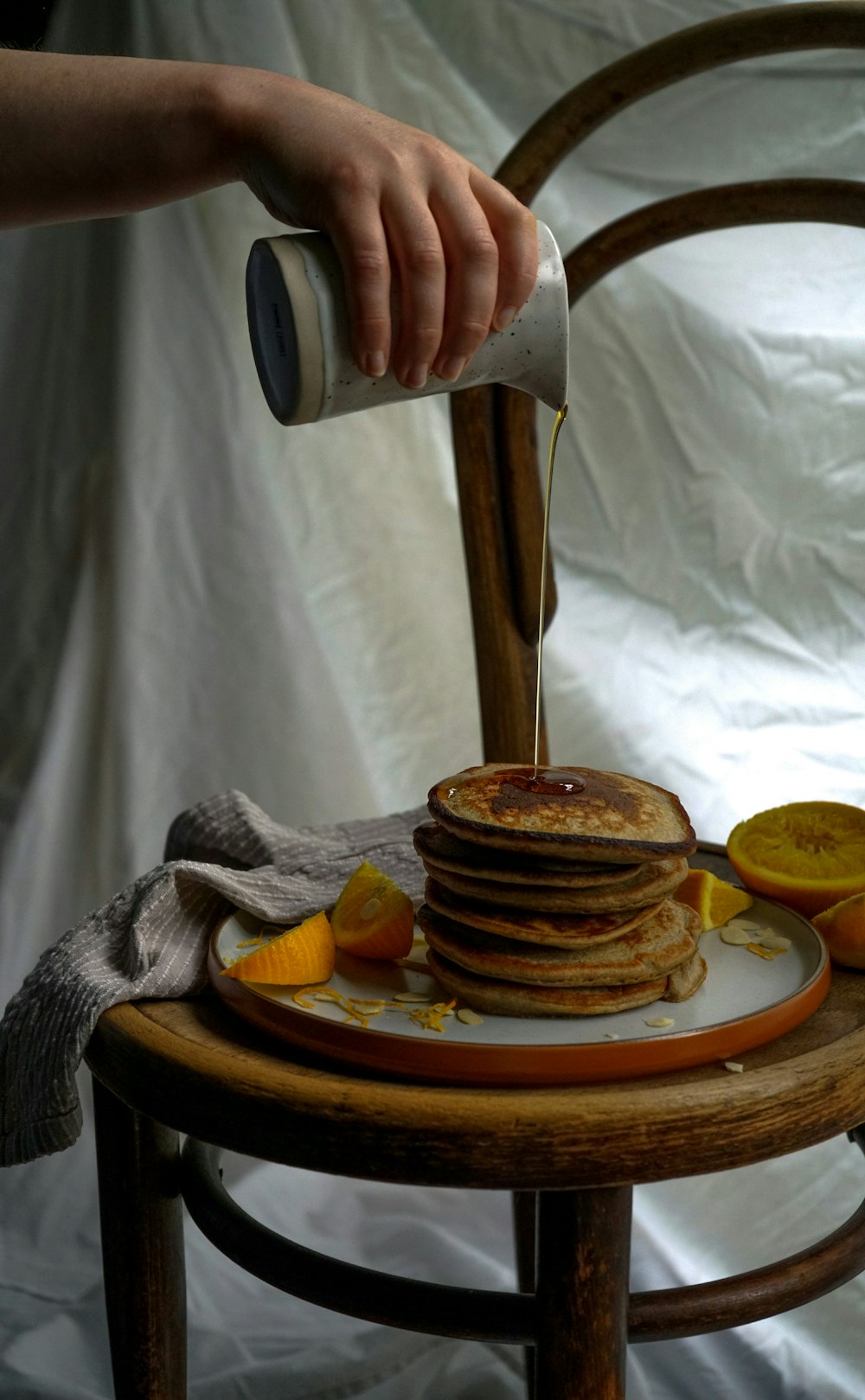 a person cutting a stack of pancakes