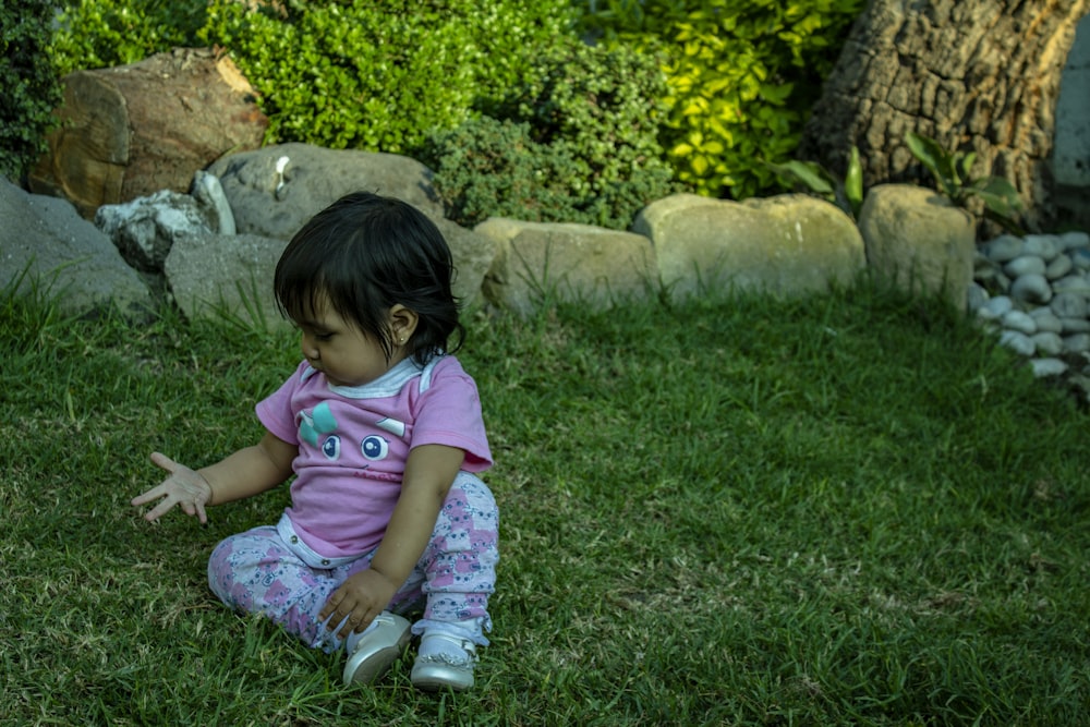 una bambina che si siede nell'erba
