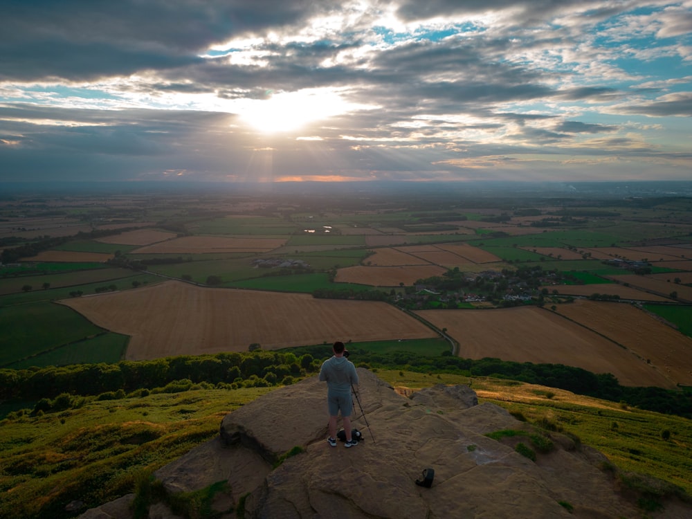 a man standing on a rock overlooking a valley