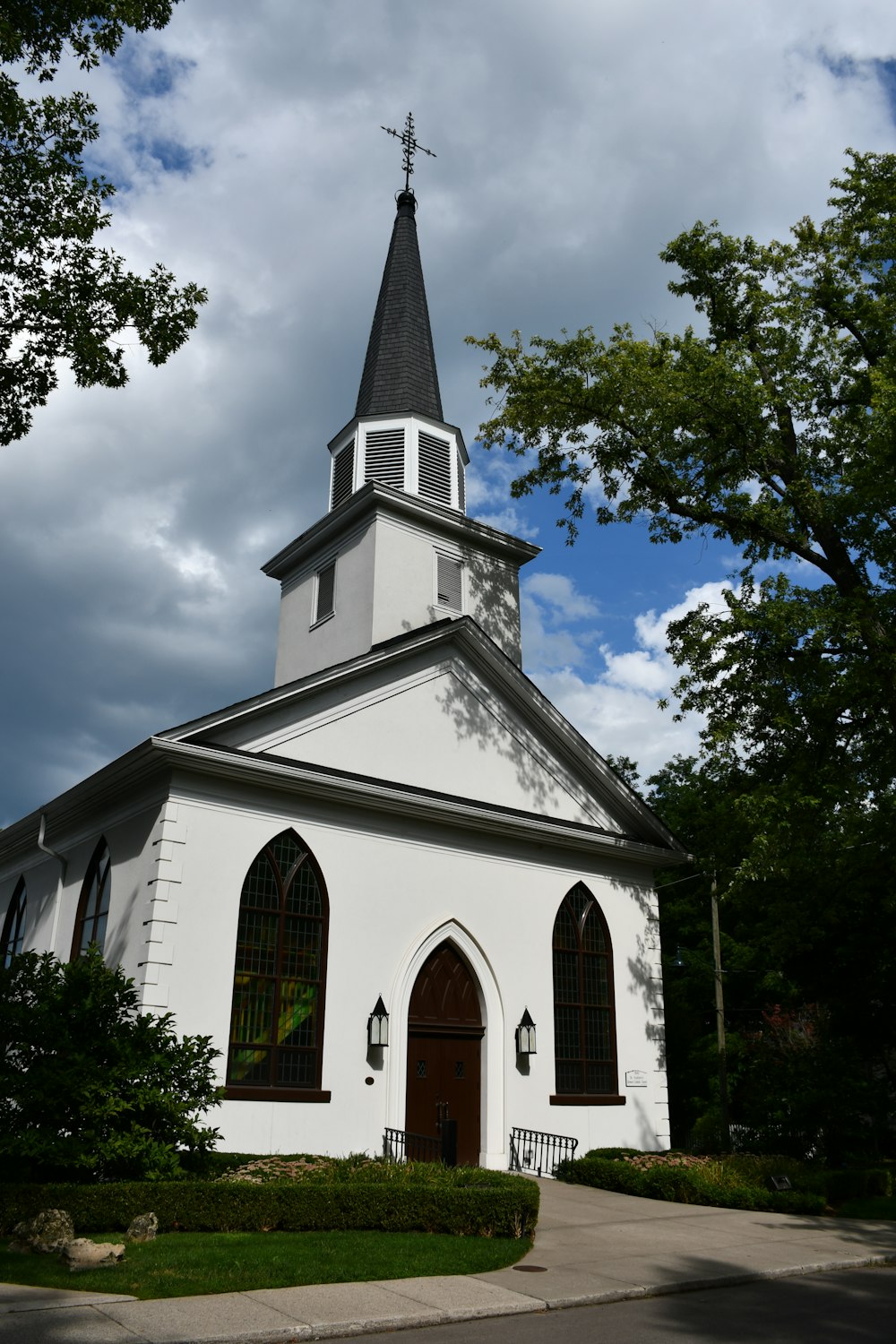 a white church with a cross on top with Confederate Memorial Chapel in the background