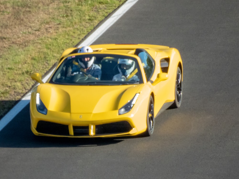 a yellow sports car on a road