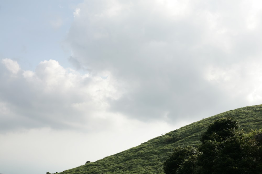 a green hill with clouds